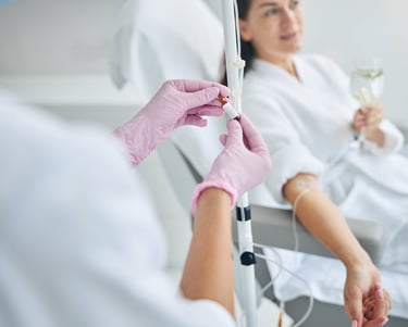 nurse giving an iv drip of vitamin to a woman