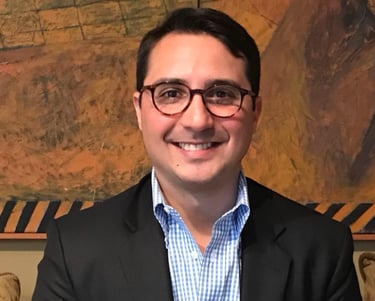 a man in a suit and glasses smiling