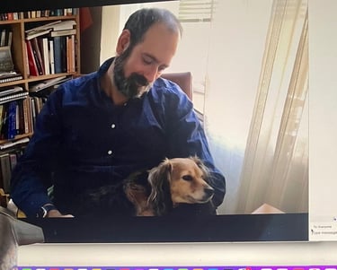 Therapist psychologist sitting on chair with small dog on his lap