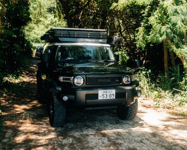 Toyota FJ Cruiser parked on a sandy trail surrounded by lush greenery in Okinawa. | Evertrail Okinawa