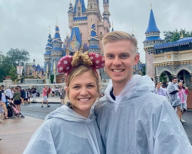 Kasey Kalk pictured with her husband in front of Cinderella Castle at Disney's Magic Kingdom®.