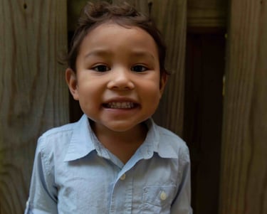 A young boy smiling at the camera.