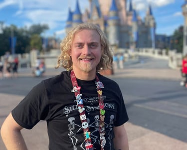 Minnie's Travel Boutique travel advisor Zach Stout pictured in front of Cinderella Castle at Disney's Magic Kingdom® Park.