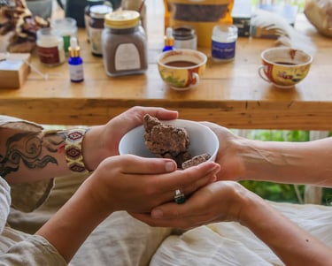 Two people holding a bowl of raw ceremonial cacao chunks during a ritual wellness ceremony.