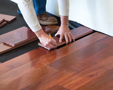 a person is holding a piece of wood flooring