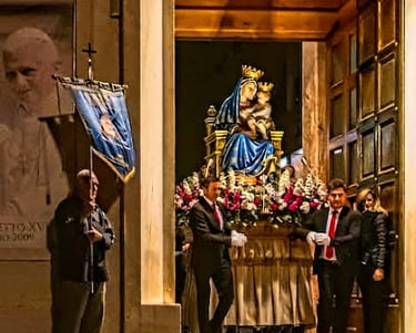 Carrying of a statue of Our Lady next to picture of the pope