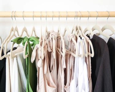 Organized clothing rack featuring a selection of neutral linen-toned tops.