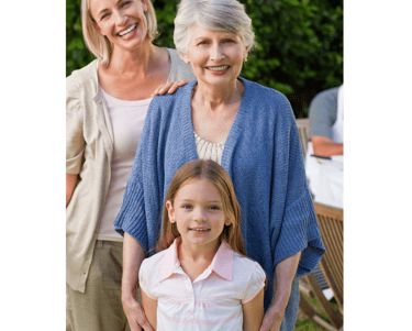 a young girl, a woman and her mother (grandmother) standing in front of a table