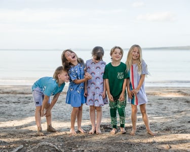 a group of children standing on a beach