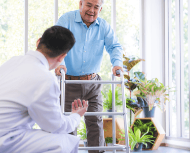 a Physiotherapist in a white shirt and a man in a blue shirt and a walker