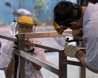 永技企業工程師團隊在工廠內焊接不鏽鋼框架,專注於精密製作與設計。