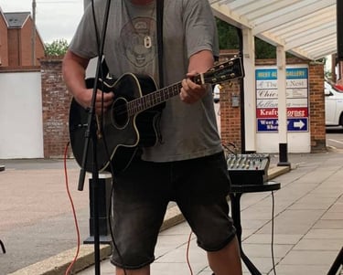 Man busking on the street with a guitar