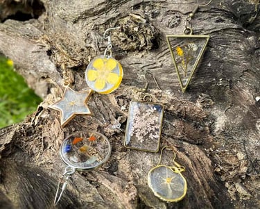 boucles-d'oreilles colorées et uniques posées sur une souche d'arbre