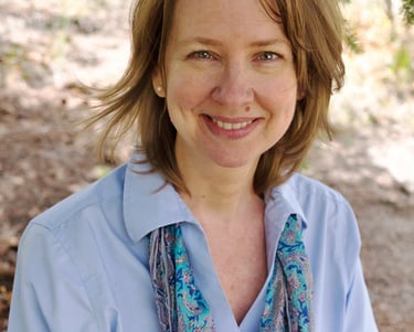 a woman in a blue shirt and scarf around her neck