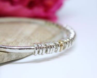 A personalised silver bangle with an anniversay message hand stamped on the inside.