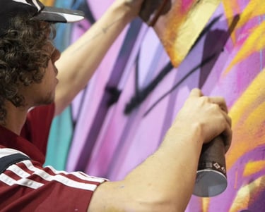 un homme avec une casquette entrain de peindre un graff