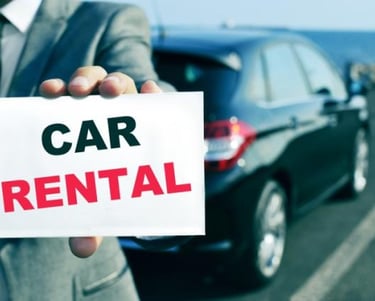 a man in a suit and tie holding a car rental sign