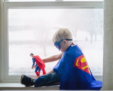 Super hero kid playing with a super hero toy
