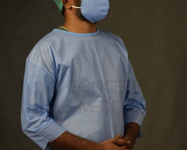 A man in a patient gown and surgical mask