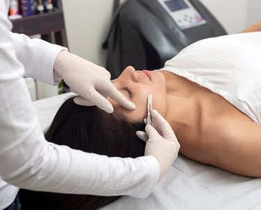 Profession esthetician performing dermaplaning treatment to client