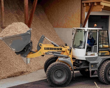 ein radlader mit einer schaufel voll mit Hackschnitzel hackgut biomasse