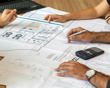 a group of people sitting at a table with papers and calculator