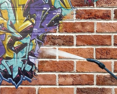 Graffiti being removed from brick wall, in toronto