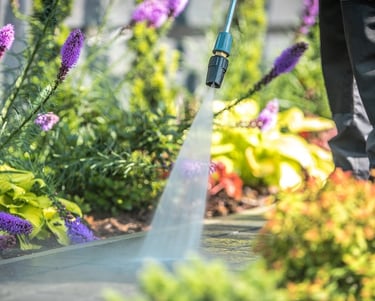 Man pressure washing residential walkway