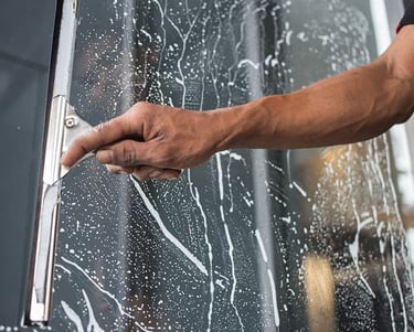Man cleaning window with squeegee in Toronto