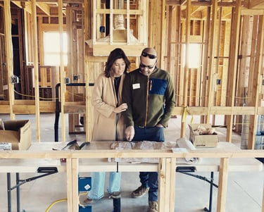 a man and woman standing in a house under construction