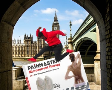 Photo of a Painmaster box with the Parliament of Westminster in the background and a young man jumping over it.