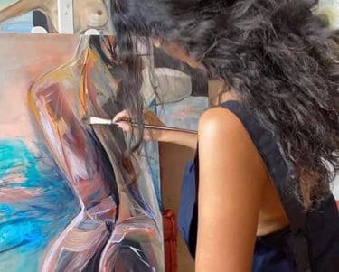 Sherezade Morales painting a captivating woman's silhouette on canvas.