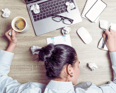 a woman sitting at a desk with a cup of coffee