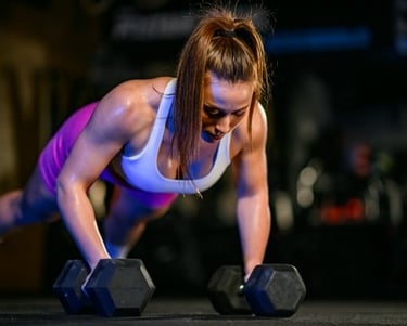 a woman doing pushups on a dumbbell