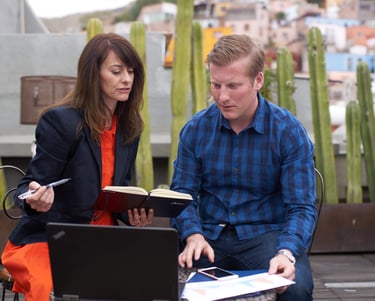 a man and woman sitting on a bench in a city