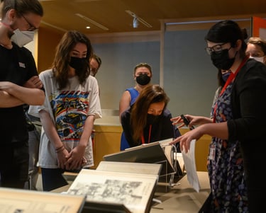 a group of people standing around a table looking at books
