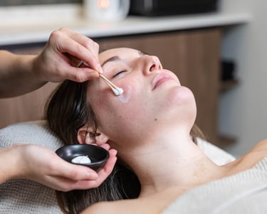 a woman getting her face covered in a mask at a salon