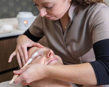 a man getting his eyebrows waxed at a salon