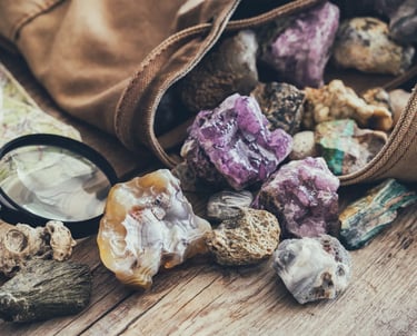 varias piedras preciosas saliendo de un bolso sobre una mesa de madera