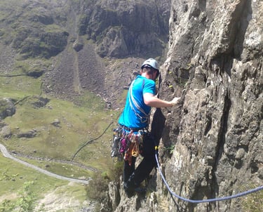 climber high on a rockface, traversing