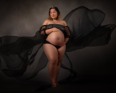 a pregnant woman in a black dress with a veil