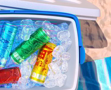 Cerveja Aurora em 3D, lata vermelha em cooler com gelo, ambiente de praia.