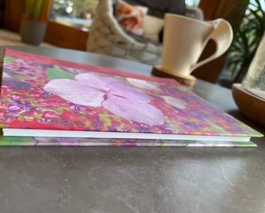 a one of a kind pink and green floral print notebook on a coffee table