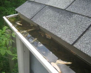 a gutter system not draining properly and leading to a buildup of debris and water