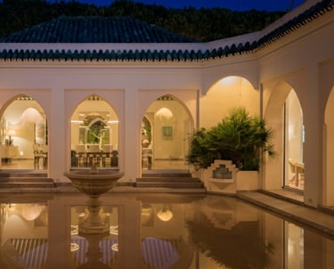 Courtyard at Villa El Rincon featuring a central fountain surrounded by flooded reflective flooring and classic arches.