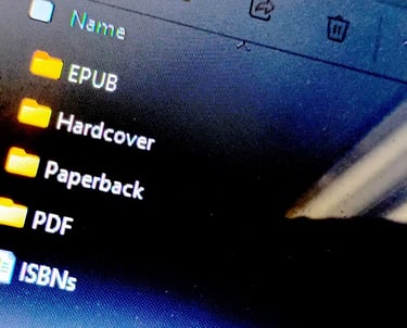 Close-up of a computer screen showing folders labeled EPUB, Hardcover, Paperback, and PDF