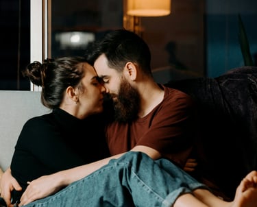 Ein Mann und eine Frau kuscheln verliebt am Sofa