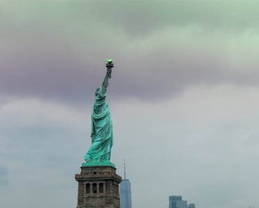 statua della libertà con piedistallo in pietra e sfondo di cielo plumbeo