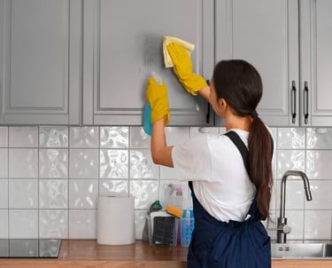 Woman cleaning kitchen tiles with yellow gloves – house cleaning service