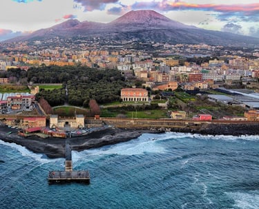 Mt. Veruvius behind homes and coastline in Naples Italy
